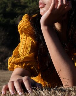 She laid down on the dry grass, in the dress someone made slowly by hand, with silence, with love.